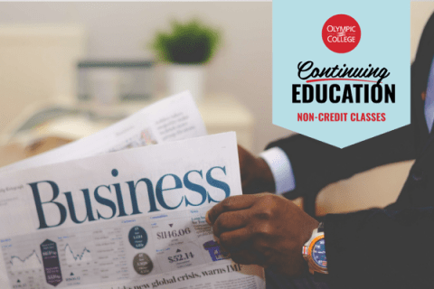Closeup of man wearing a suit holding the business section of a newspaper. Text reads, "Olympic College Continuing Education Non-Credit Classes"