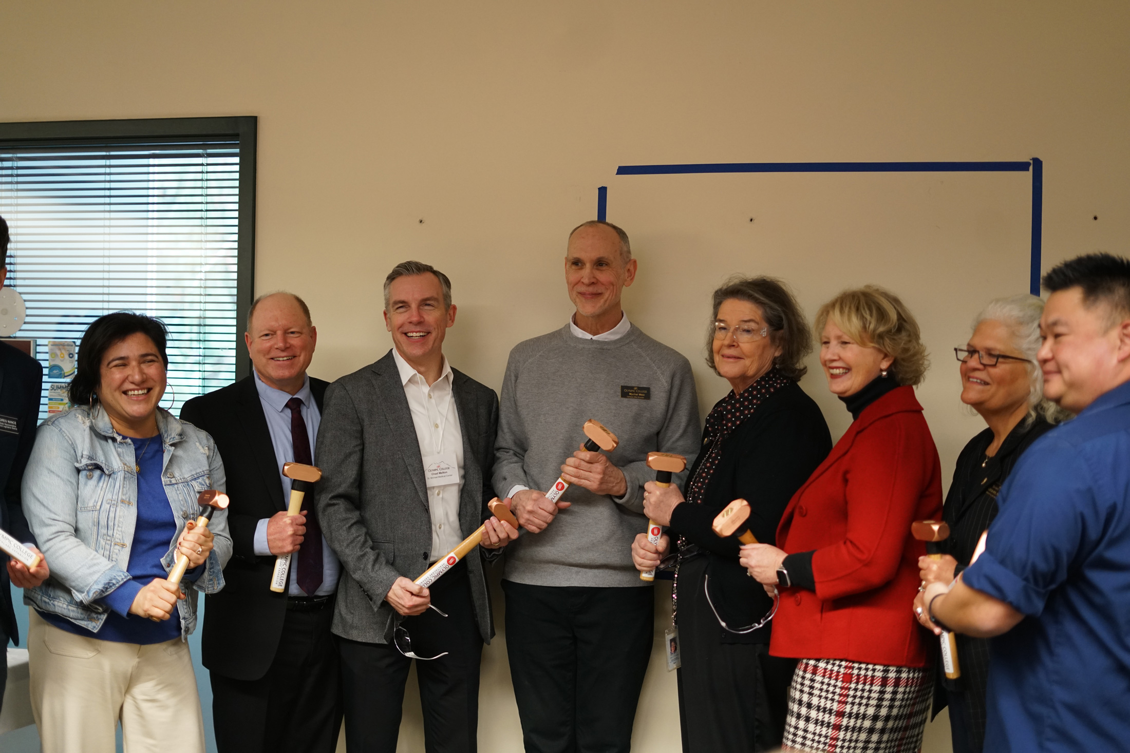 Speakers gather with commemorative sledgehammers.