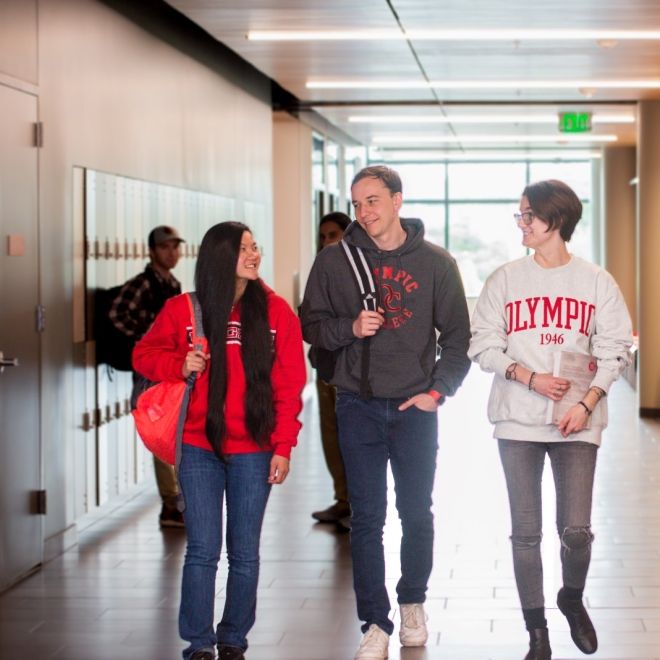 group of smiling students walking down the hallway
