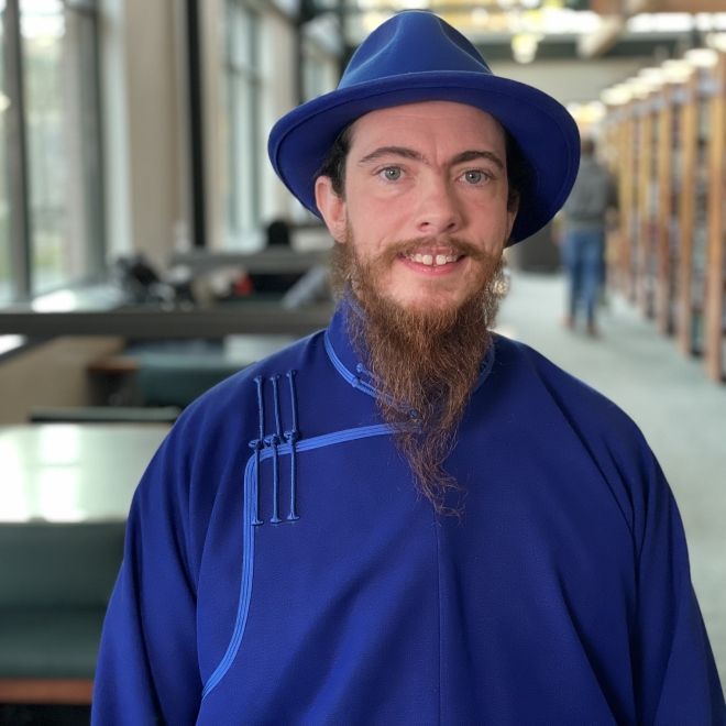 Smiling student poses near windows in Haselwood Library