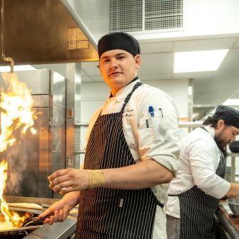 Culinary Student with flaming pan.