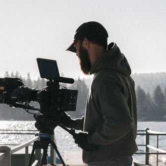 Student filming on a dock.