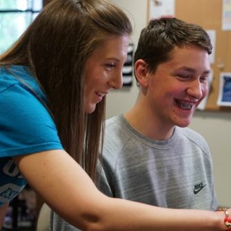 Female with student at computer.