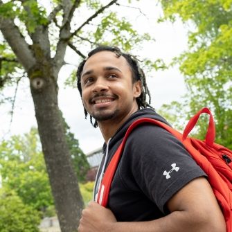 Male student with backpack outside. 