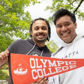 Two male students with OC pennant. 