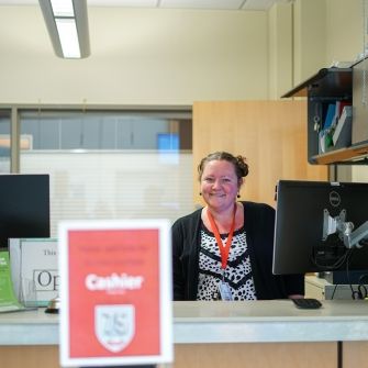 Cashier smiling from behind counter