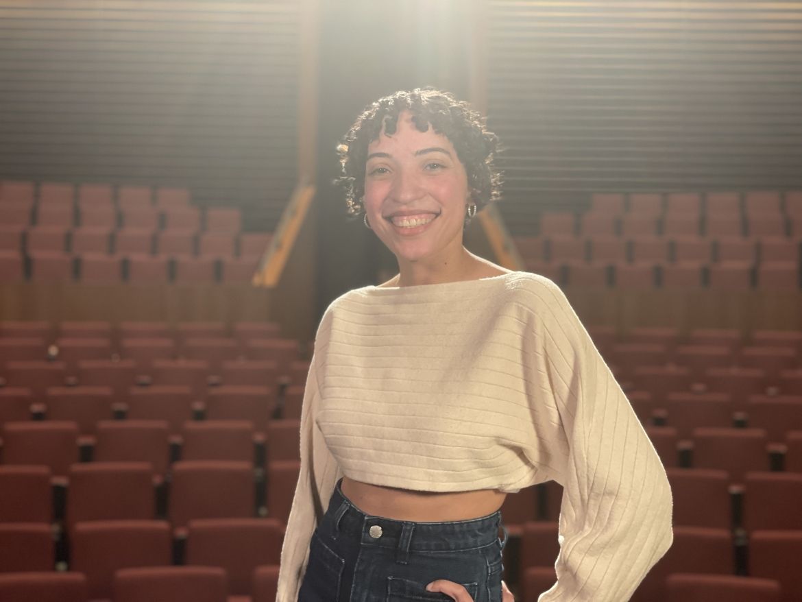 Smiling student on stage in the William D. Harvey Theater