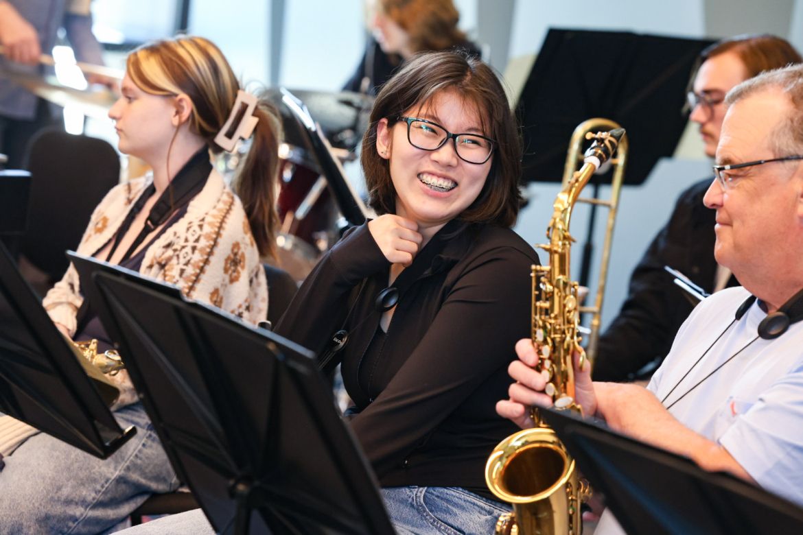 Student smiling with music ensemble