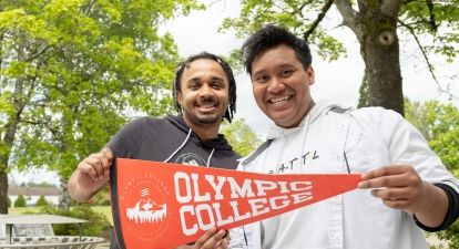Two male students with OC pennant. 