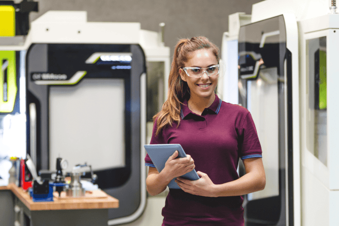 Female student operating CNC machine. 