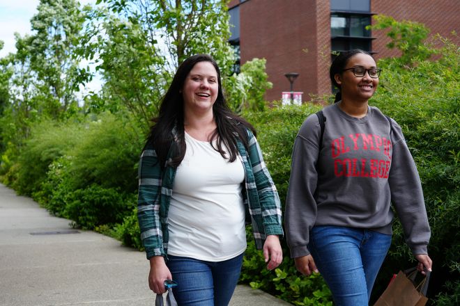 Two students walking together across campus.