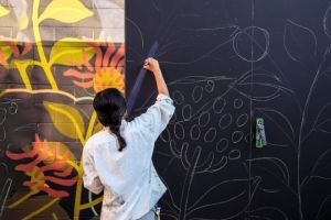 Photo of a woman painting a mural