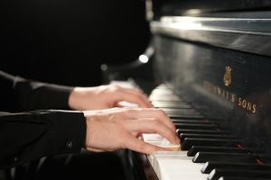 Fingers on a piano keyboard.