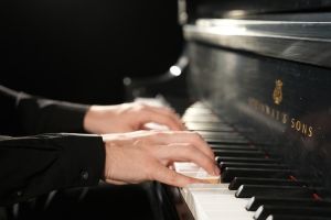 Fingers on a piano keyboard.