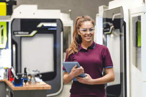 Female student operating CNC machine. 