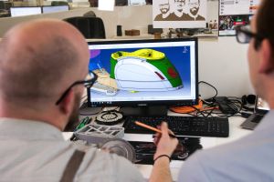 Student and teacher evaluate a 3D design on a computer