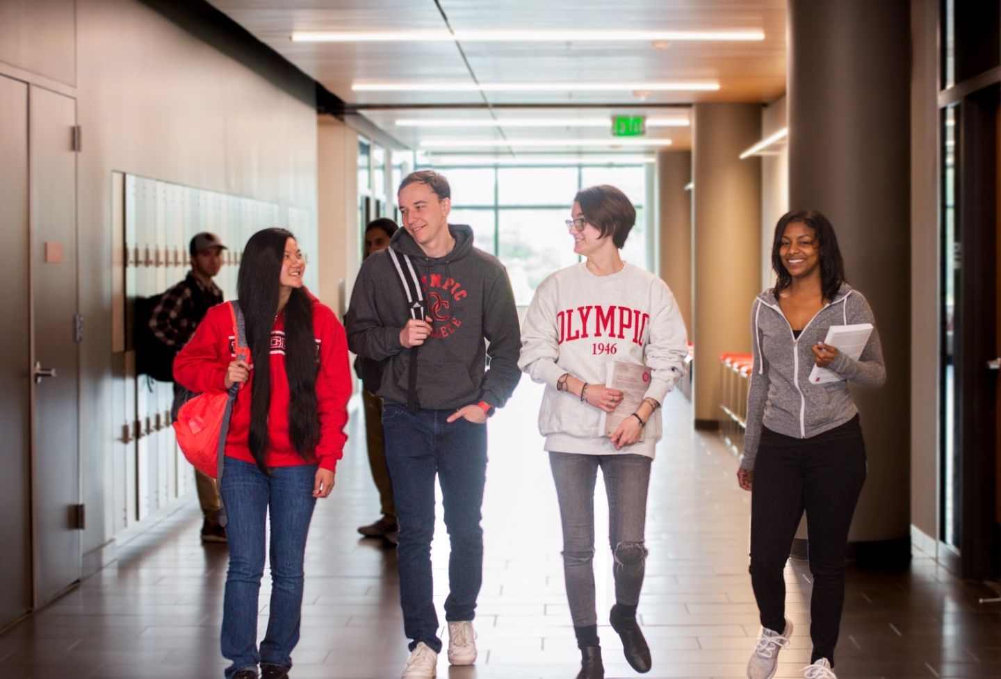group of smiling students walking down the hallway