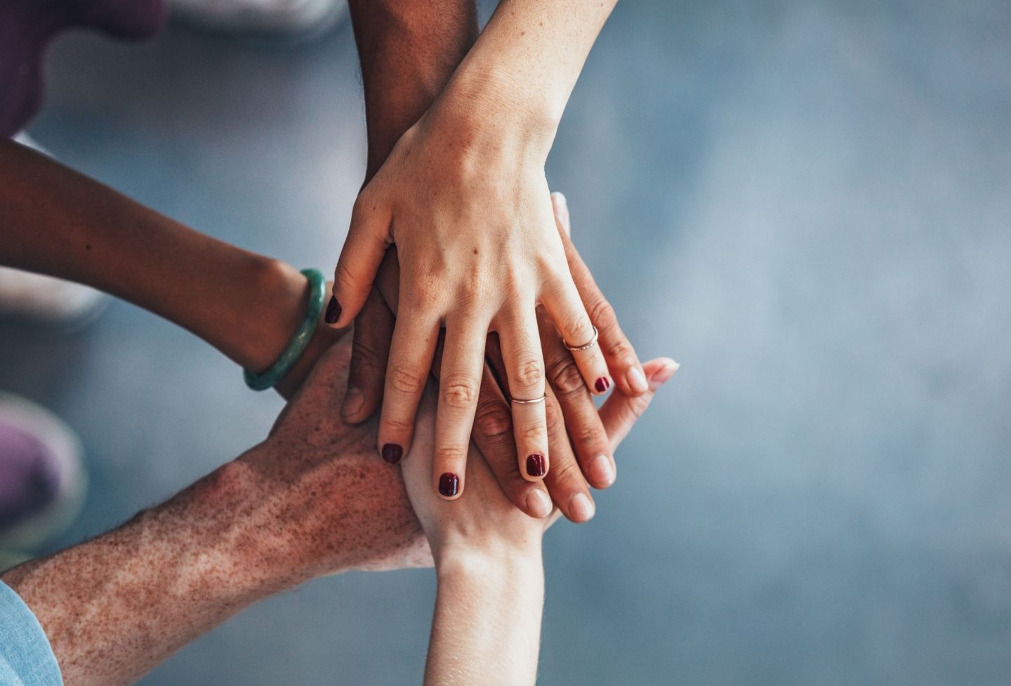 Photo of a group of people putting their hands together in a sign of mutual support