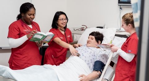 Three nursing students in simulation lab.