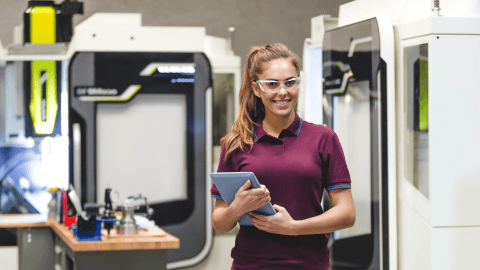 Female student operating CNC machine.
