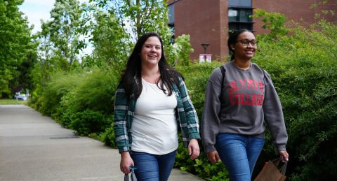 Two students walking together across campus.