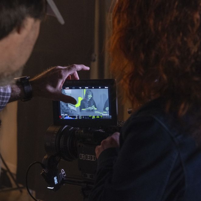 Filmmaking professor and student observing monitor