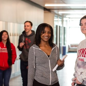 Four students in a hallway together. 