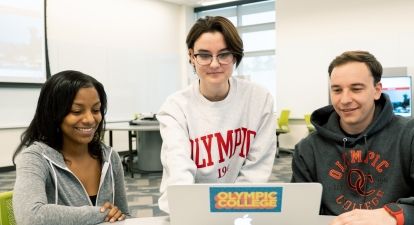 Three students at a laptop.