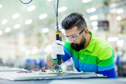 A man works at a workbench on a manufacturing project